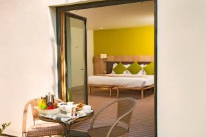 a room with a bed and a table and a mirror at Lifehouse Spa And Hotel in Frinton-on-Sea