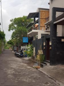an empty street with a motorcycle parked next to a building at 24/7 Bed & Breakfast in Jimbaran