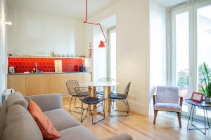 a living room with a couch and a table and chairs at Casa René - Charming apartments in Almada