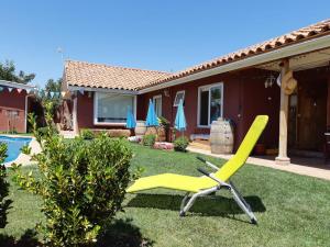 una sedia gialla da prato nel cortile di una casa di Alojamiento Los Nogales a Rancagua
