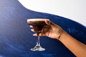 a person holding a wine glass on a table at voco - Oxford Spires, an IHG Hotel in Oxford