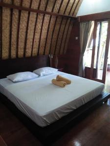 a bed with two towels sitting on top of it at Gili Smile Bungalow in Gili Trawangan