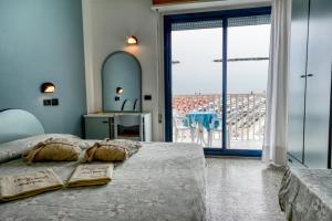 a bedroom with a bed and a view of the ocean at Hotel Royal in Cesenatico