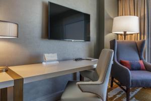 a hotel room with a desk and a tv at Omni Louisville Hotel in Louisville