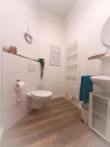 een witte badkamer met een toilet en een wastafel bij Gemütliche Ferienwohnung Soltau in Soltau