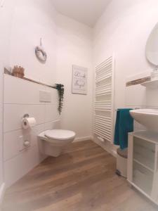 a white bathroom with a toilet and a sink at Gemütliche Ferienwohnung Soltau in Soltau