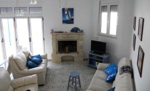 a living room with two couches and a fireplace at Villa Eleonora in Kókkinon Khoríon