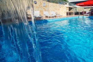 een zwembad met een glijbaan in het midden bij Apartments Toni 2000 in Podstrana