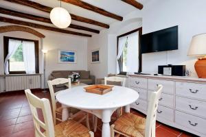 a kitchen and living room with a white table and chairs at Agriturismo Pimpinnacolo in Porto Ercole