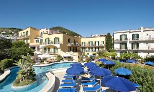 un complejo con una piscina con sombrillas y sillas azules en Hotel Royal Terme, en Isquia