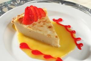 a piece of cheesecake with a strawberry on a plate at Holiday Inn Hermosillo, an IHG Hotel in Hermosillo