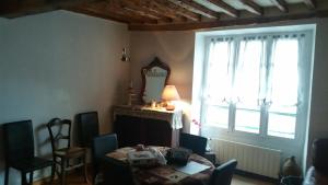 a dining room with a table and a window at La maison des vacances in Auzat