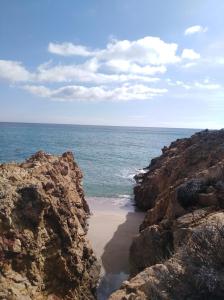 una playa rocosa con vistas al océano en Abbaechelu en Santa Margherita di Pula
