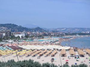 una playa con muchas sillas y sombrillas y agua en La casa di Alvy, en Pescara
