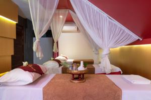 a bedroom with two beds with curtains and a table at King Rock Residence in Siem Reap