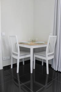una mesa de comedor blanca y 2 sillas en una habitación en Duque de Loulé - Apartments - Apartamento E, en São Martinho do Porto