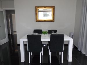 mesa blanca con sillas negras y espejo en Duque de Loulé - Apartments - Apartamento E, en São Martinho do Porto