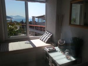 einen Fensterplatz in einem Zimmer mit Meerblick in der Unterkunft Varkiza Seaside Penthouse with Private Roof Deck in Vari