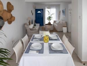 a dining room with a white table and chairs at Protaras Villa Nicol 21 in Paralimni