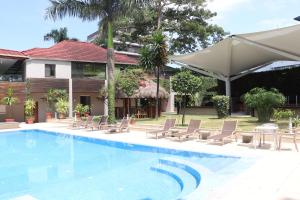 einen Pool mit Stühlen und ein Haus in der Unterkunft Mamba Point Hotel in Monrovia