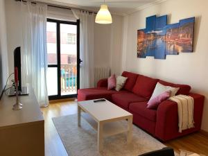 a living room with a red couch and a table at La Vie en Rose Piso en el centro in Briviesca