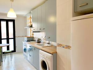 a white kitchen with a washer and a dishwasher at La Vie en Rose Piso en el centro in Briviesca +5 photos