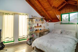 a bedroom with a white bed and a wooden ceiling at Home for Air -- 9 minutes from sea of Galilee in Giv'at Yo'av