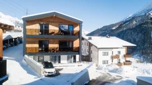 budynek w śniegu z samochodem z przodu w obiekcie Arula GmbH w mieście Sankt Anton am Arlberg