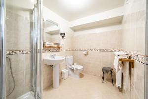 a bathroom with a toilet and a sink and a shower at Karlamuiza Country Hotel in Kārļi