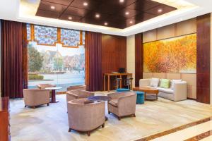 a lobby with a waiting room with a couch and chairs at Holiday Inn Taizhou CMC, an IHG Hotel in Taizhou