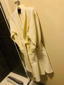 a white sweater hanging on a rack in a bathroom at Grimscote Manor Hotel in Coleshill