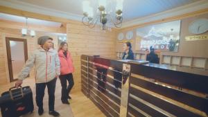 two women with luggage standing in front of a counter at Ski Paradise Karakol in Karakol