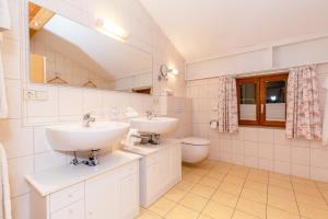 a bathroom with two sinks and a toilet at Gästehaus Flora in Reit im Winkl