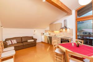 a kitchen and living room with a table and a couch at Gästehaus Flora in Reit im Winkl