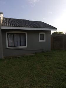 a small house with a grass yard in front of it at Puleng's Granny Flat in Richards Bay
