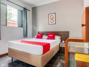 a bedroom with a bed with red pillows at Hotel Park Leste, São Paulo in Sao Paulo