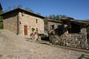 an old stone house with a cobblestone street at Podere Pian De' Cortini in Serravalle