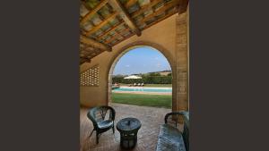 an arched doorway to a patio with chairs and a pool at Villa Ponte in Ponte dʼArbia