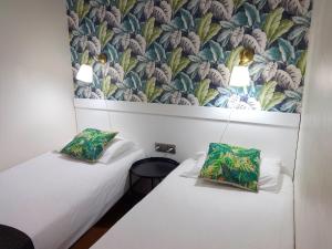 - 2 lits dans une chambre avec une fresque murale dans l'établissement Ledglass Barcelona, à Barcelone