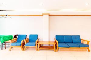 een wachtkamer met blauwe stoelen en een tafel bij Oun Residence in Hat Yai