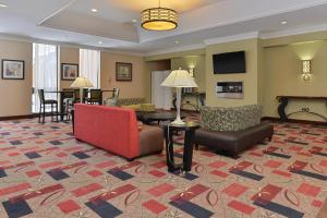 un vestíbulo de hotel con un sofá rojo y sillas en Holiday Inn New London, an IHG Hotel en New London