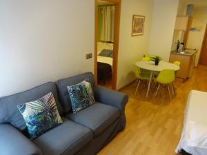 a living room with a blue couch and a table at Ledglass Barcelona in Barcelona