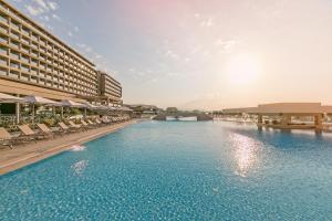 een groot zwembad naast een hotel bij Amada Colossos Resort in Faliraki