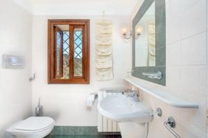 bagno bianco con lavandino e servizi igienici di Corbezzoli a San Teodoro