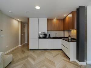 a kitchen with white cabinets and wood floors at San Sebastian Suites in Cartagena