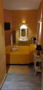 a bedroom with a yellow bed and a window at Villamereu in Pula
