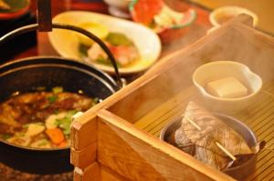 Okuhida Garden Hotel Yakedake في تاكاياما: طاولة مع وعاء من الطعام وعاء من الشوربة
