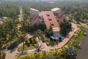an aerial view of a house with a swimming pool and palm trees at Sunray Village Resort in Bhogāpuram