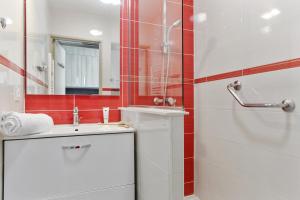 a bathroom with a sink and a shower with a mirror at Résidence Pierre & Vacances La Corniche d'or in Boulouris-sur-Mer