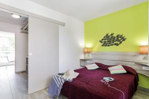 una camera da letto con un grande letto con una coperta viola di Résidence Pierre & Vacances La Corniche d'or a Boulouris-sur-Mer